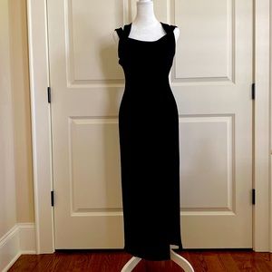 Black evening dress. Slit on left front. Strappy back with silver buckles.